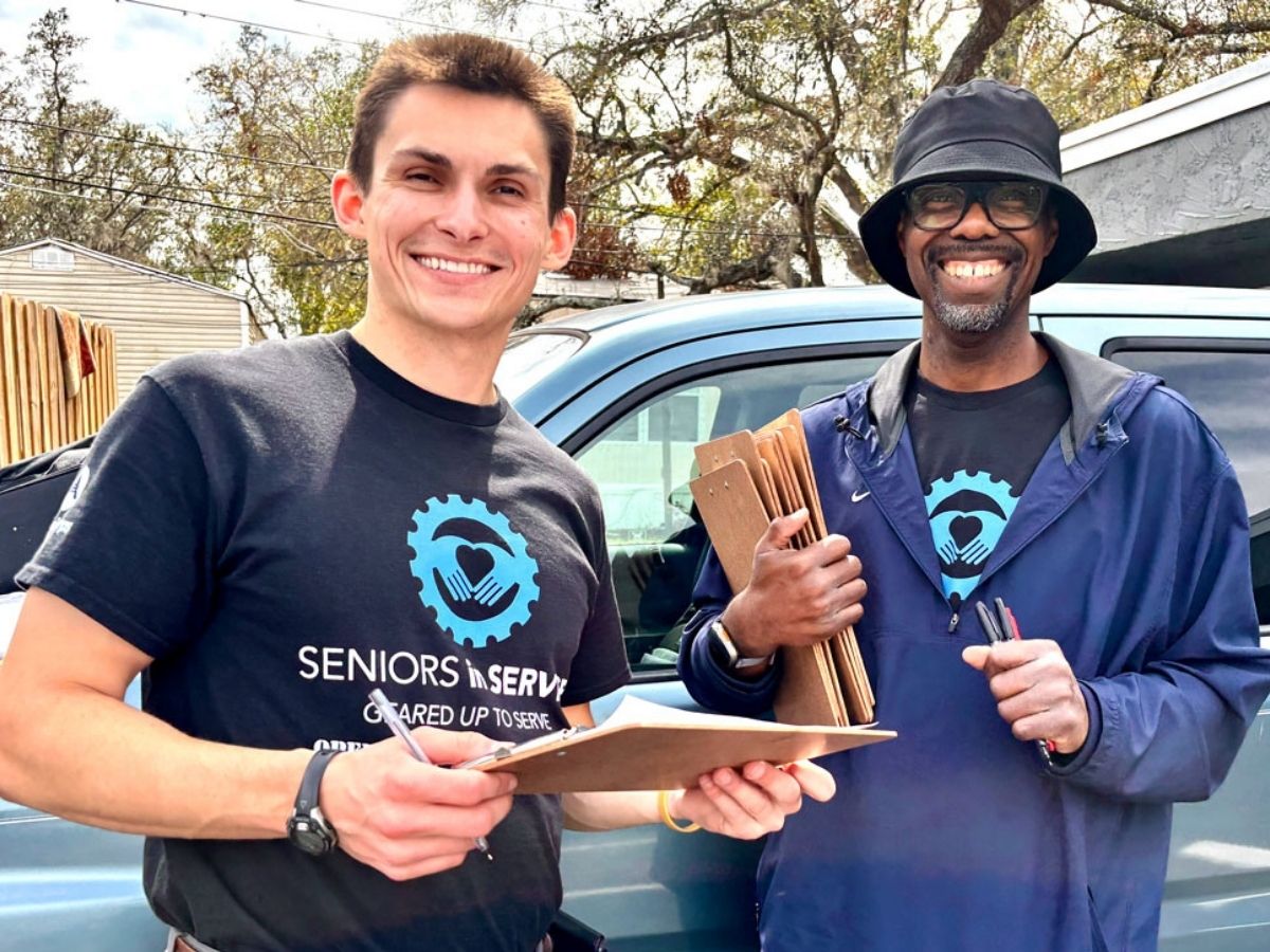 Seniors in Service staff member Greg with Operation: Veteran Connect member outside a community event