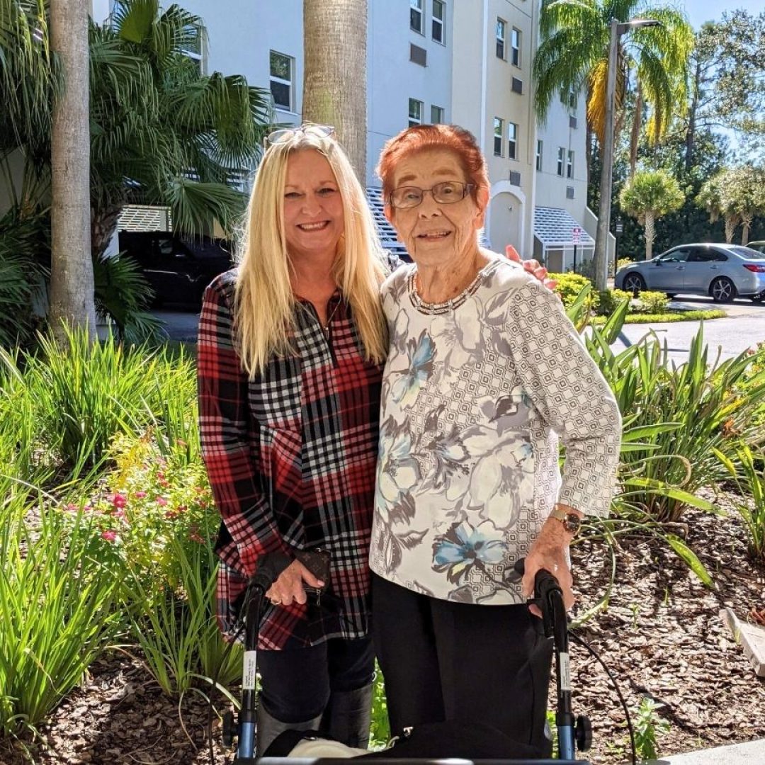 An AmeriCorps Seniors volunteer stands outside smiling with her Seniors in Service Senior Companion Program member.