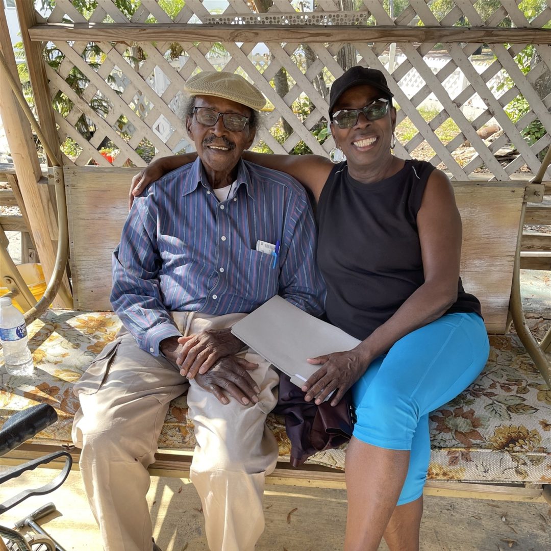 A Seniors in Service Senior Companion Program member sits outside with his AmeriCorps Seniors volunteer companion.